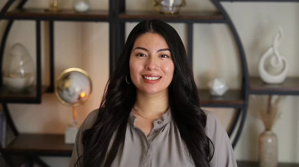 a therapist smiling at the camera during a telehealth session.